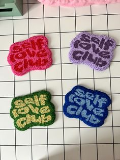 four crocheted patches sitting on top of a tiled floor next to each other