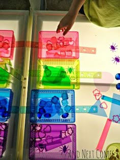 a young boy standing in front of a refrigerator filled with magnets