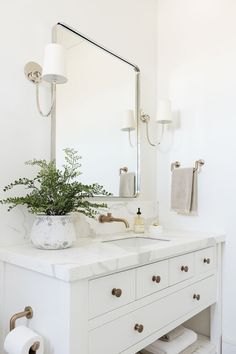 a bathroom with a sink, mirror and toilet paper roll holder on the counter top