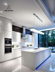 a modern kitchen with white cabinets and counter tops, along with an island in the middle