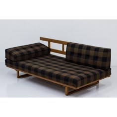 a black and brown checkered couch sitting on top of a wooden frame