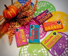 several candy bars sitting on top of a doily next to an orange and pumpkin