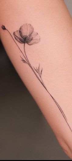 a single flower tattoo on the arm