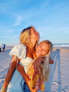 two women hugging each other on the beach