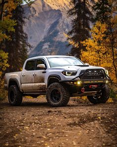 a white truck parked on top of a dirt road