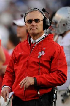 an older man wearing headphones on the sidelines