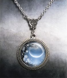 Winter Solstice Art Nouveau necklace ~ Celebrate the Yuletide season with this beautiful image of falling snow and new moon.   The pendant measures 1-3/16" across (30mm) and the artwork is covered by a crystal clear, domed glass cabochon which protects and enhances the image for a truly beautiful effect!   The necklace closes with a lobster clasp and has a 2" extension chain, so an 18" necklace will adjust up to 20", a 21" necklace adjusts up to 23", etc.  If you would prefer to not have the extension chain, please leave us a note at checkout. We have 4 chain lengths available at checkout and custom lengths are also available at no extra charge. Please visit Moon Garden Designs on Etsy for many more unique and beautiful pendant and necklace designs: http://www.moongardendesigns.etsy.com Round Winter Jewelry Gift, Round Jewelry Gift For Winter, Handmade Round Jewelry For Christmas, Handmade Round Christmas Jewelry, Nickel-free Mystical Round Necklaces, Nickel Free Round Mystical Necklace, Nickel-free Round Mystical Necklace, Solstice Art, Full Moon Necklace