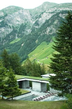 the house is surrounded by mountains and pine trees