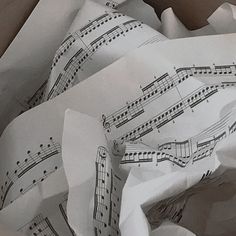 an open box with sheet music on it's wrapping paper and scissors in it