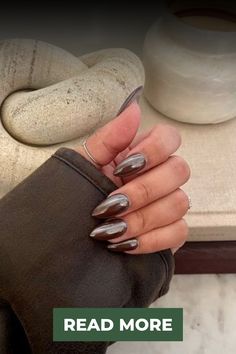 a woman's hand with silver nail polish on it and the words read more