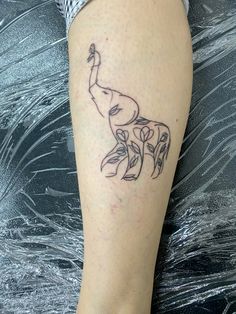 a woman's leg with a tattoo of a giraffe and leaves on it