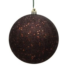 an ornament with brown speckles hanging from a green cord on a white background