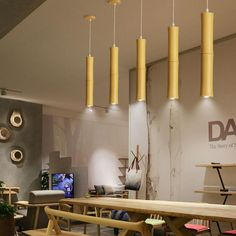 a room filled with lots of wooden tables and chairs next to a wall mounted tv