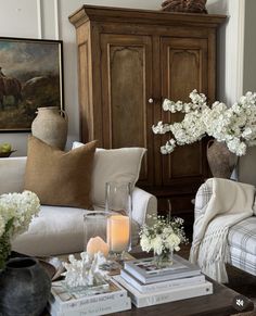 a living room filled with furniture and flowers on top of it's coffee table