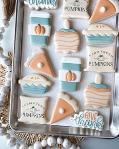 decorated cookies in the shape of pumpkins and pies on a tray with decorations