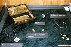 an old wooden box sitting on top of a display case filled with necklaces and jewelry