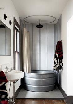 a bathroom with a tub, sink and mirror