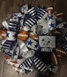 a football wreath made out of silver and blue ribbon