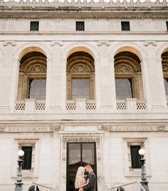 a bride and groom standing in front of an ornate doorway at the san francisco county courthouse