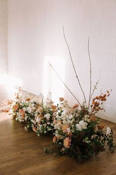 an arrangement of flowers is arranged on the floor