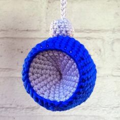 a crocheted blue and white ball hanging from a rope