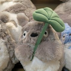 stuffed animals are lined up in a row and one has a green leaf on it