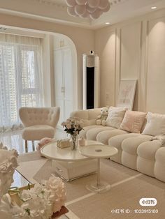 a living room filled with white furniture and flowers