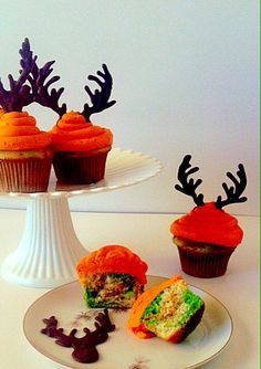 some cupcakes are sitting on a plate with fake antlers in the background