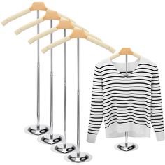 four clothes hangers and three sweaters on them