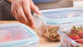 a person picking up food from plastic containers