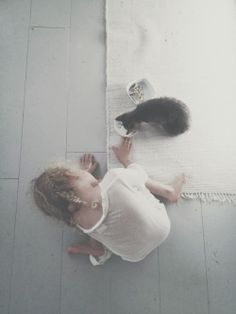 a woman laying on the floor next to a black and white cat with a quote