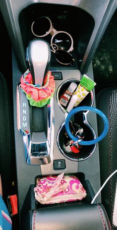 the interior of a car with various items in it, including a cup holder and steering wheel