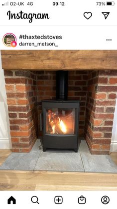 a wood burning stove sitting inside of a brick fireplace