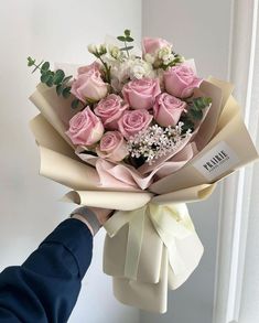 a person holding a bouquet of pink roses