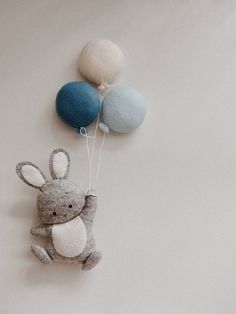 a stuffed animal with two balloons attached to it's back on a white surface