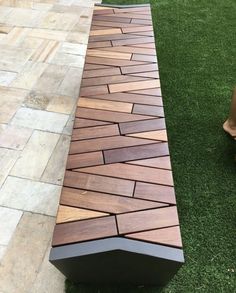 a wooden bench sitting on top of a lush green grass covered park area next to a brick walkway