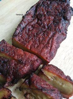 sliced up meat sitting on top of a wooden cutting board