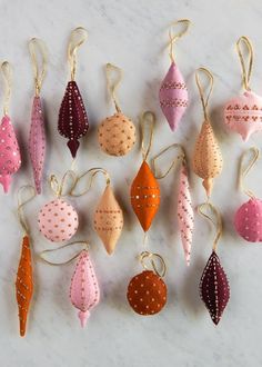 a bunch of ornaments hanging from strings on a wall