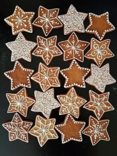 some cookies are decorated with icing and sprinkles on a black surface