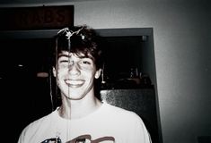 a young man is smiling in front of a mirror with wires attached to his head