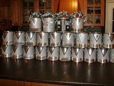 a bunch of silver cups sitting on top of a kitchen counter next to each other