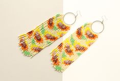 These boho style beaded earrings are made in Latvia  of high-quality Czech beads and strong synthetic thread.    Hypoallergenic Earring Hooks. Earrings are 17 cm ( 6.7 inches)  length with hooks and 5.5 cm ( 2.1 inches) width. Colors: yellow,orange,brown,green. 100% handmade. Don't forget to check out my other jewelry in the store. Maybe you will find exactly what you are looking for. https://www.etsy.com/shop/SandasHandmades The photo may not convey true colors. This may depend on the settings Artisan Multicolor Round Beaded Earrings, Bohemian Multicolor Round Beaded Earrings, Bohemian Multicolor Beaded Round Earrings, Multicolor Large Beaded Round Earrings, Multicolor Bohemian Hand-strung Beaded Earrings, Quartz Hoop Earrings, Funny Earrings, Statement Hoop Earrings, Beaded Earrings Native