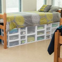 a bedroom with a bed, desk and storage bins