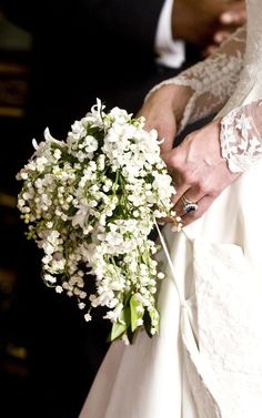 a bride holding a bouquet of white flowers