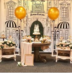 a table with cake and balloons in front of a wall decorated with an ornate arch