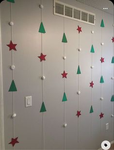 the wall is decorated with green and red christmas trees