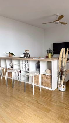 a living room filled with furniture and a flat screen tv on top of a wooden floor