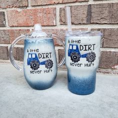 two blue and white mugs sitting next to each other on a table near a brick wall