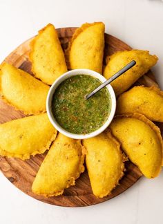 some fried food on a wooden plate with dipping sauce