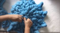 someone is knitting something blue on the floor